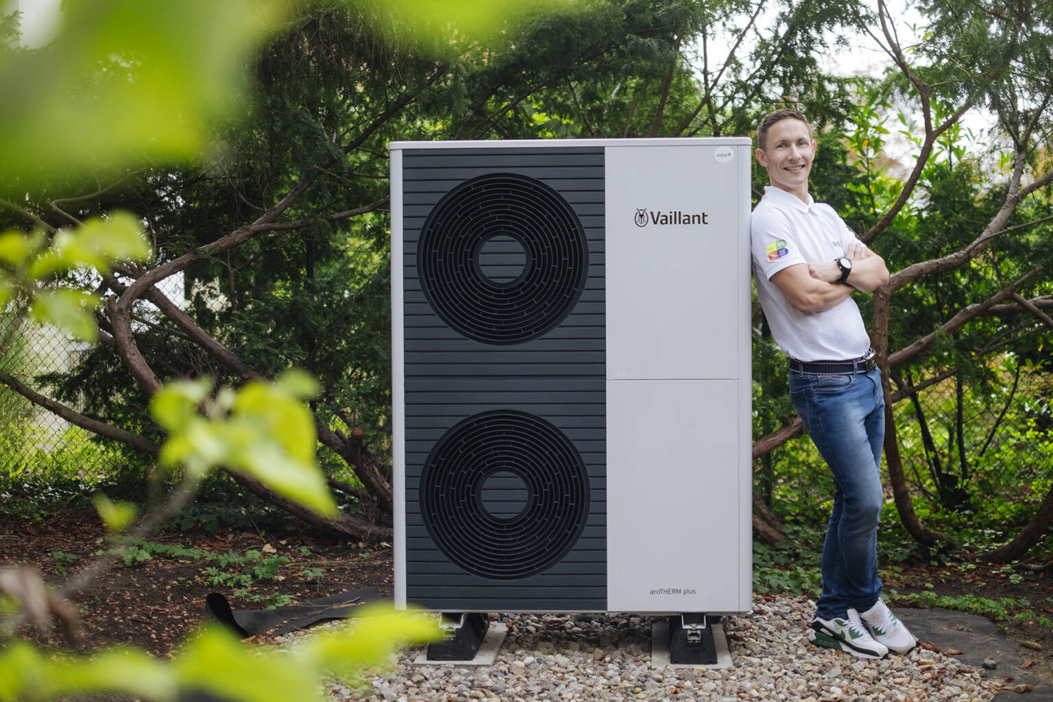 Eine Wärmepumpe der Bien Gmbh in einem Vorgarten daneben steht der Berater der Bien GmbH