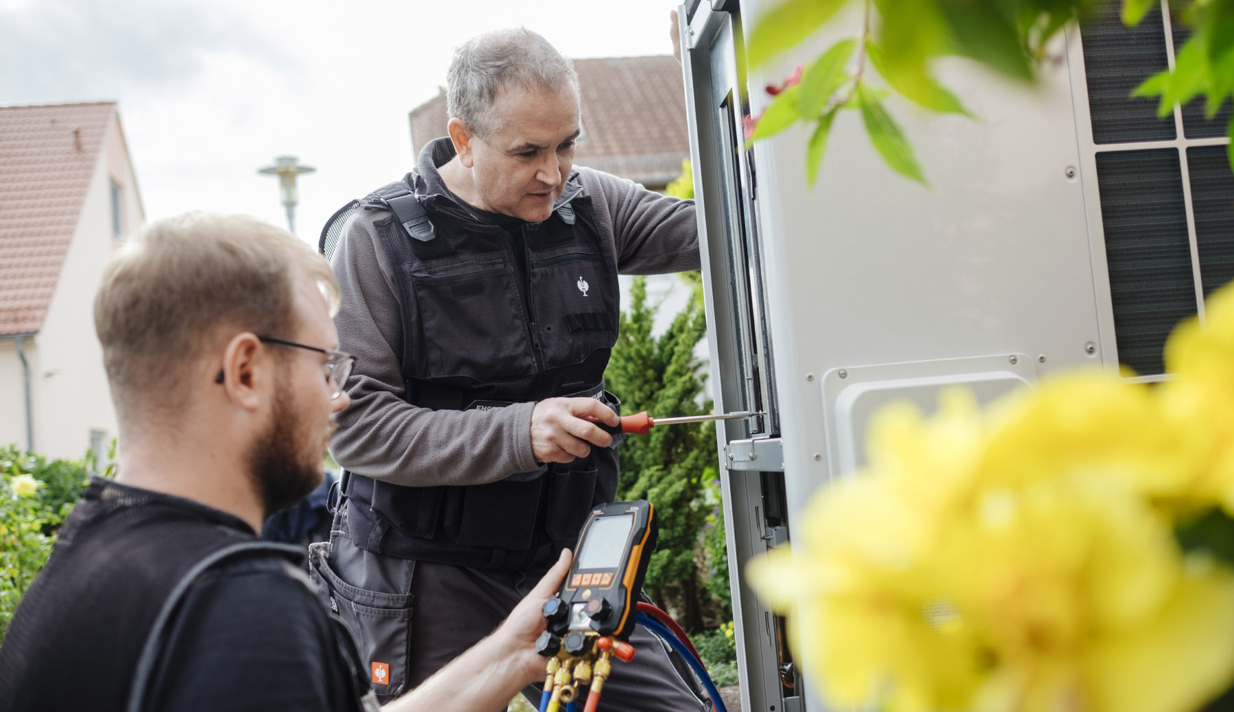 Servicetechniker bei der Installation und Wartung einer modernen Wärmepumpe – Informationen zu Funktion, Vorteilen, Nachteilen und Kosten von Wärmepumpen im Überblick.