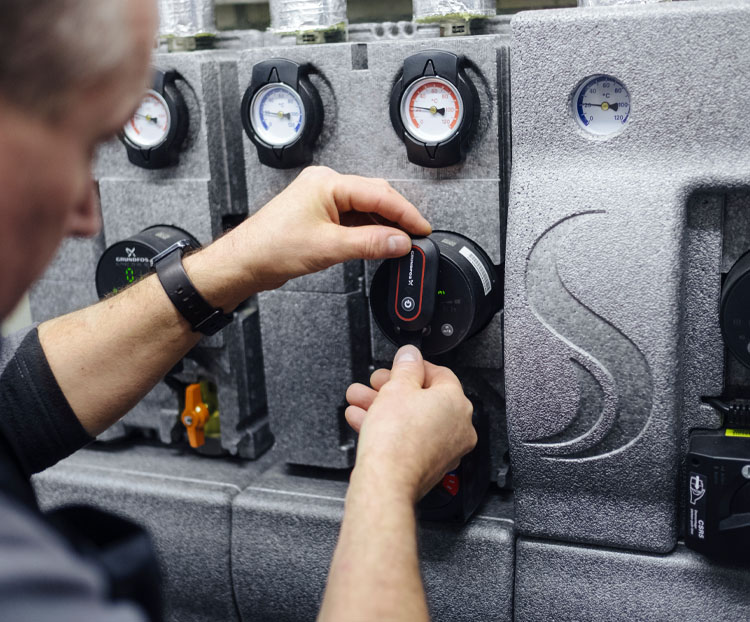 Techniker stellt Heizungs- und Wärmepumpentechnik ein – moderne energieeffiziente Haustechnik für nachhaltiges Heizen und geringere Energiekosten.