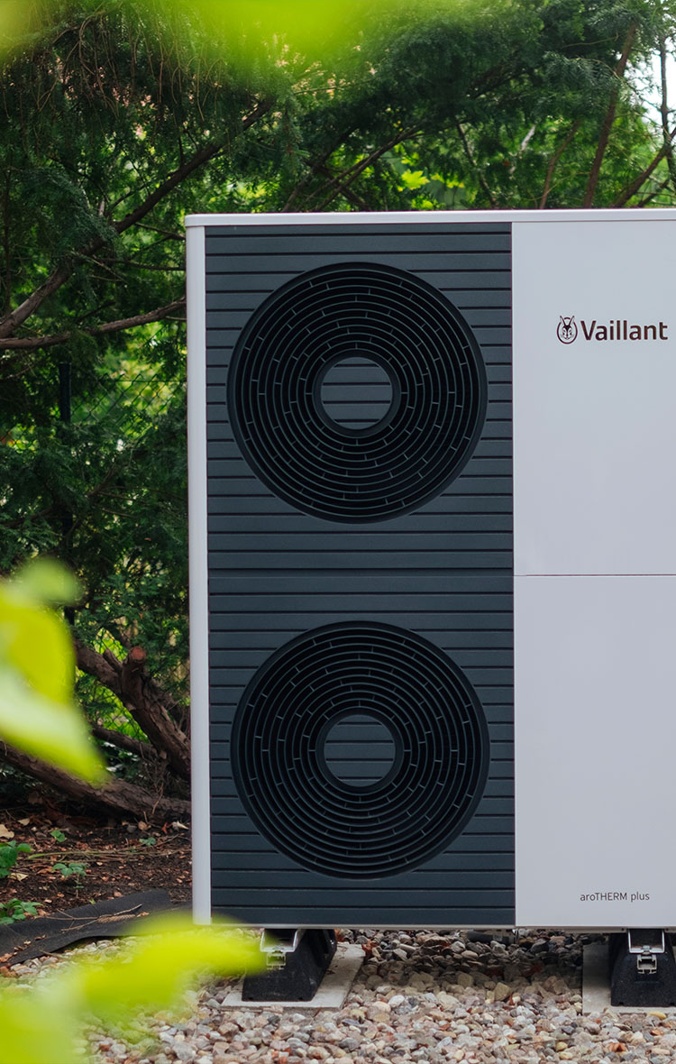 Modernes Außengerät einer Vaillant Luft-Wasser-Wärmepumpe im Garten – energieeffiziente Heizlösung für nachhaltiges Heizen im Einfamilienhaus.