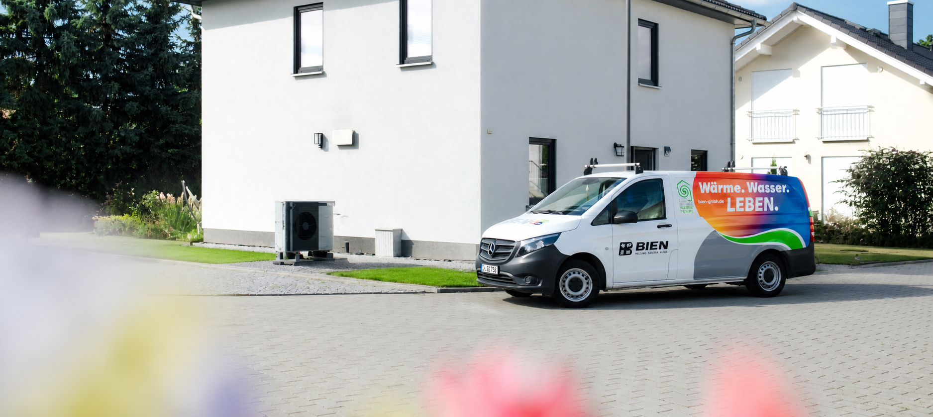 Servicefahrzeug der Bien GmbH vor einem modernen Einfamilienhaus mit installierter Wärmepumpe – nachhaltige Heiztechnik und Heizungsmodernisierung in Berlin.