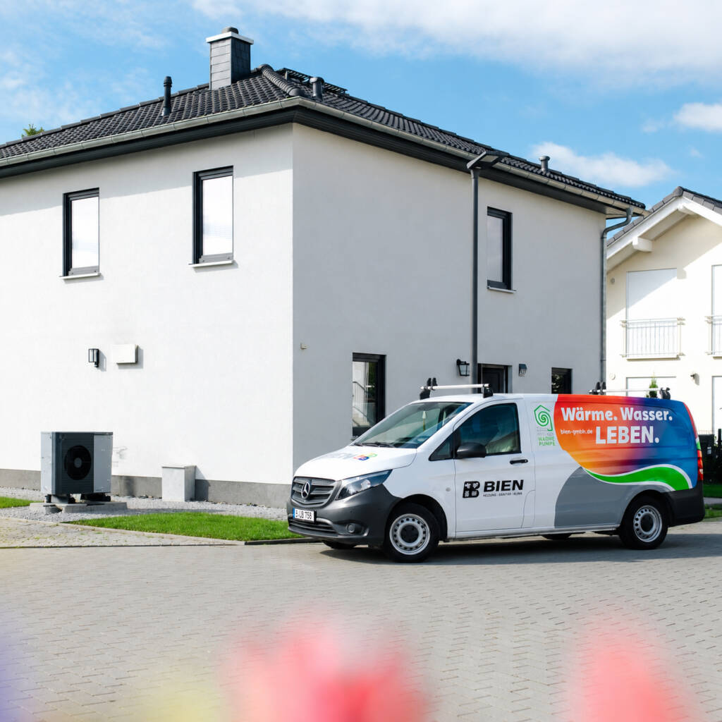 Servicefahrzeug der Bien GmbH vor einem modernen Einfamilienhaus mit installierter Wärmepumpe – nachhaltige Heiztechnik und Heizungsmodernisierung in Berlin-Pankow.
